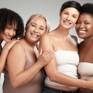 Shot of a diverse group of women standing and hugging each other in the studio